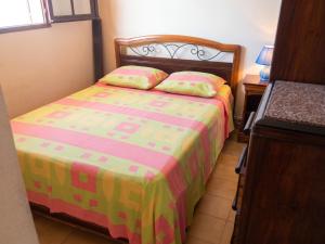 a small bedroom with a bed with a colorful bedspread at Maison charmante vue sur mer à La Trinité, 2 chambres. in La Trinité