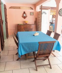 a dining room with a blue table and chairs at Maison charmante vue sur mer à La Trinité, 2 chambres. in La Trinité +7 photos