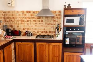 a kitchen with a stove and a microwave at Maison charmante vue sur mer à La Trinité, 2 chambres. in La Trinité