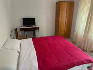 a bedroom with a bed with a red blanket on it at Mountain Bloom House in Galda de Sus +1 photo