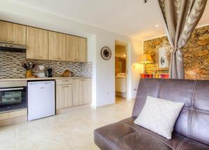 a living room with a couch and a kitchen at Studio accueillant à Moltifao 30 m² avec terrasse et jardin in Moltifao