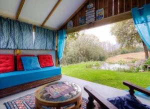 a room with a couch and a table on a porch at Studio accueillant à Moltifao 30 m² avec terrasse et jardin in Moltifao