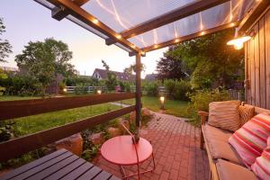 a patio with a table and a bench and a pergola at Tiny House Gerswalde in Gerswalde