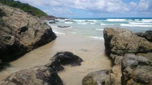 a beach with some rocks and the ocean at Casa temporada na praia Joia do Atlântico - Ilhéus - Ba in Ilhéus