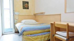 um pequeno quarto com uma cama e uma secretária em Hotel Eva em Milão