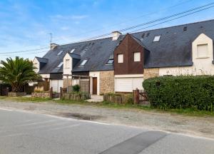 a large white house with a black roof at Appartement charmant à Sarzeau avec vue sur la mer, 55 m² in Sarzeau