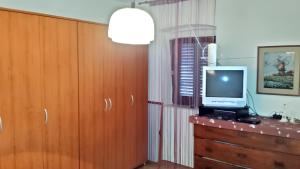 a room with a tv on top of a dresser at Spacious Apartment in Zlarin + terrace in Zlarin