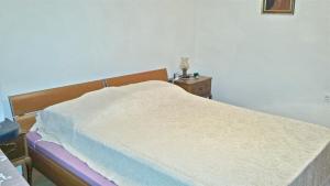 a bedroom with a bed and a dresser with a night stand at Spacious Apartment in Zlarin + terrace in Zlarin