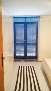 a bedroom with a bed and a blue door at Spacious Apartment in Zlarin + terrace in Zlarin +6 photos