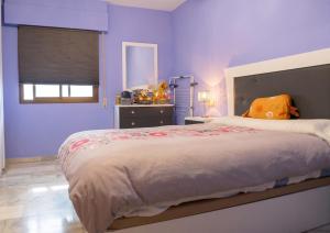 a bedroom with a large bed with purple walls at Comfortable Apartment in Almuñécar in Almuñécar