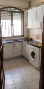 a kitchen with a washing machine and a window at Comfortable Apartment in Almuñécar in Almuñécar +4 photos