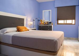 a bedroom with a large bed in a blue room at Comfortable Apartment in Almuñécar in Almuñécar