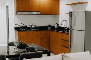 a small kitchen with a refrigerator and a table at The One Apartment in Rawai Beach +10 photos
