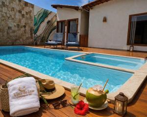 a pool with a table with a towel and sunglasses at Vista do Luar Corumbau in Prado