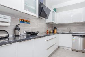 a white kitchen with white cabinets and a stove at Charming House in Costa Calma with Mountain View and Terrace in Costa Calma