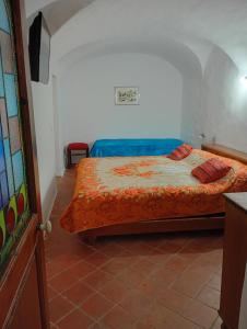 a bedroom with a bed with an orange comforter at Casa Arancia in Isolabona