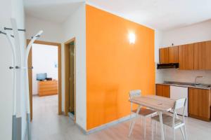 a kitchen with an orange wall and a table and chairs at Romantic Apartment in Vieste - 40 m² with Sea View in Vieste