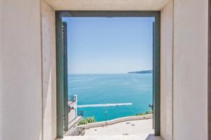 a window view of the ocean from a building at Romantic Apartment in Vieste - 40 m² with Sea View in Vieste