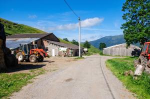 a tractor parked on a dirt road next to a barn at Appartement charmant avec vue sur lac et montagne – 75 m² in Fontrabiouse +6 photos