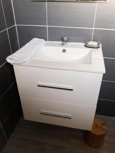 a bathroom with a white sink and a mirror at Villa charmante au Moule avec piscine in Le Moule