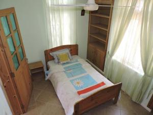 a small bedroom with a bed and a book shelf at Charming villa in Blue Bay with private pool in Blue Bay