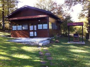 a small cabin in the grass with a chair in front at Comfortable Chalet in Giarola with Mountain View in Busana