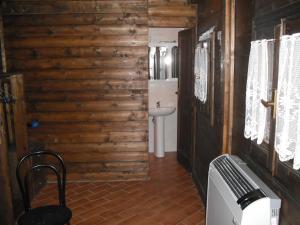 a bathroom with a toilet and a sink at Comfortable Chalet in Giarola with Mountain View in Busana