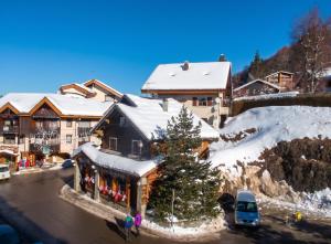a building with a christmas tree in the snow at Studio accueillant à Les Carroz, 27 m², vue montagne in Les Carroz d'Araches