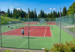 a group of people playing tennis on a tennis court at Studio accueillant à Les Carroz, 27 m², vue montagne in Les Carroz d'Araches