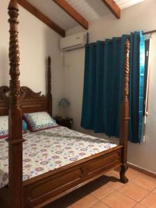 a bedroom with a canopy bed with blue curtains at Appartement spacieux à Saint-François 150 m² avec piscine partagée ! in Saint-François