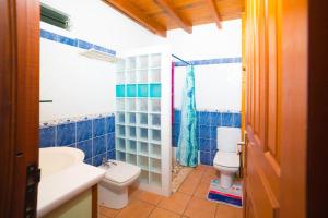 a blue tiled bathroom with a toilet and a sink at Appartement spacieux à Saint-François 150 m² avec piscine partagée ! in Saint-François