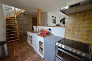 a kitchen with white counters and a stove top oven at Maison charmante au cœur d'Alligny-en-Morvan avec vue in Alligny-en-Morvan +12 photos