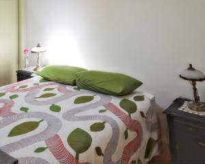 a bed with green pillows on it in a bedroom at Cozy House in Seia with Fireplace in Faia