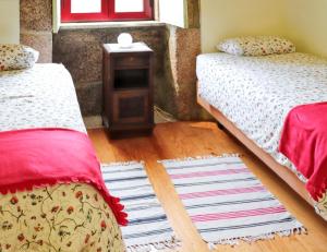 a bedroom with two beds and a table with a window at Cozy House in Seia with Fireplace in Faia