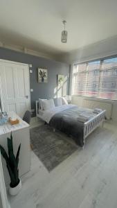 a bedroom with a bed and two windows at Papa guest in Poole
