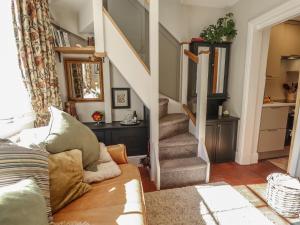 a living room with a couch and a staircase at Hangmans cottage in Horncastle