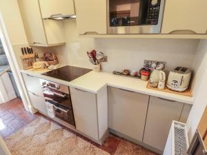 a kitchen with a counter with a stove and a microwave at Hangmans cottage in Horncastle