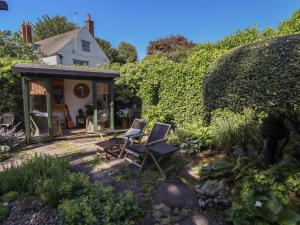 a garden with chairs and a small house at Hangmans cottage in Horncastle