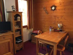 a dining room with a wooden table and a tv at Studio charmant à Valloire - 21m² - Vue sur montagne in Valloire