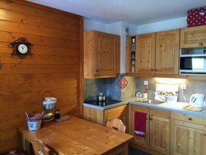a kitchen with wooden cabinets and a wooden table at Studio charmant à Valloire - 21m² - Vue sur montagne in Valloire +6 photos