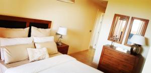a bedroom with a bed with white pillows and a mirror at Spacious apartment in La Cala de Mijas with sea view. in La Cala de Mijas