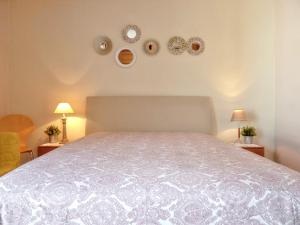 a bedroom with a white bed with plates on the wall at Charming house in Vila Nova de Cacela with garden in Vila Nova De Cacela