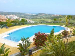a large swimming pool in a resort with plants at Spacious apartment in La Cala de Mijas with sea view. in La Cala de Mijas
