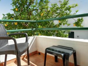a balcony with two chairs and an orange tree at Charming house in Vila Nova de Cacela with garden in Vila Nova De Cacela