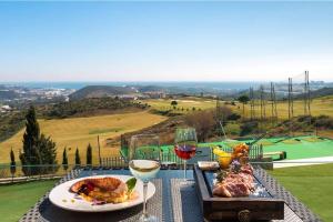 a table with a plate of food and glasses of wine at Spacious apartment in La Cala de Mijas with sea view. in La Cala de Mijas +12 photos