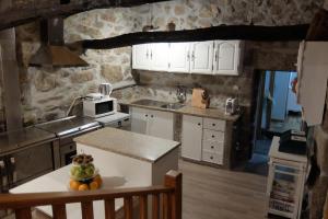 a kitchen with white cabinets and a table with fruit on it at Paradisiacal Villa in Lousada with Private Pool in Lousada