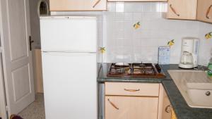 a white refrigerator in a kitchen next to a sink at Maison charmante à Montblanc avec terrasse in Montblanc +23 photos