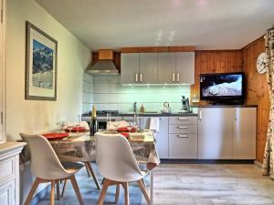 a kitchen and dining room with a table and chairs at Appartement cosy aux Carroz, 40 m², vue sur la montagne in Les Carroz d'Araches