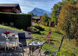 a patio with a table and chairs and a mountain at Appartement cosy aux Carroz, 40 m², vue sur la montagne in Les Carroz d'Araches +6 photos