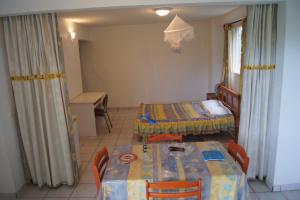 a room with two beds and a table with chairs at Studio cosy au Moule 30 m² avec jardin privé in Le Moule